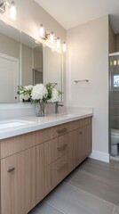 This stunning bathroom showcases a sleek design with gray and white elements and large windows providing natural light and scenic views
