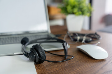 A pair of headphones resting on a laptop