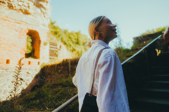 Young caucasian woman tourist walks through the ruins of an ancient castle in Europe, historical place 