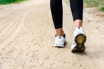 Rear view of a woman's feet before running on summer forest background.