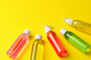 Colorful Bottles of Liquid Soap on Yellow Background