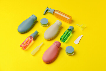 Colorful Travel-Sized Bottles and Containers on a Yellow Background