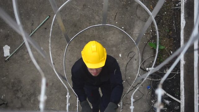 Technical service engineer climbing up on the fixed ladder to check the solar panel on the roof top.