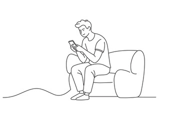  The young man is sitting on the sofa checking the message on his cell phone One line continuous line art vector illustration on white background.