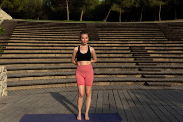 Young Redhead Woman Practicing Yoga Outdoors on a Sunny Day