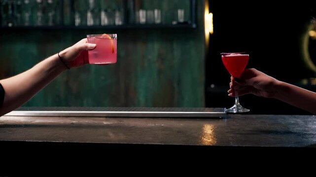 two people cheering cocktails in bar or disco club drinks and cocktails concept