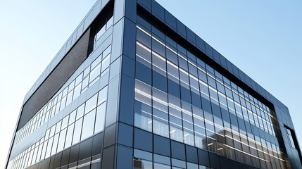 Obraz premium A grey modern office building with reflective glass windows and clean lines