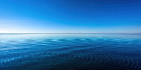 Fototapeta premium Clear blue sky reflecting on the calm ocean surface with a horizon line in the distance, serene, tranquil, peaceful, clear, sky