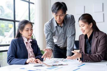 Asian business team working with financial data and using calculator