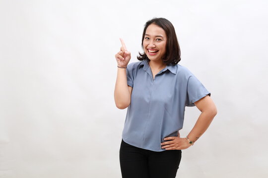 Smiling happy good-looking asian girl giving advice, showing one finger as explain rules, make point, standing white background