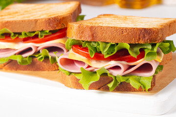 Club sandwich with ham, cheese, tomato and lettuce. 