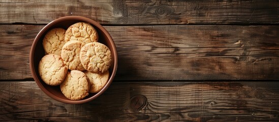 Top view of a bowl of biscuits displayed on a wooden table with ample copy space image.
