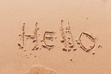 the inscription hello  on the seashore with palm trees