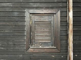Mediterranean exterior wall of a house, with a wooden window. Wooden wall. Athens, Greece.