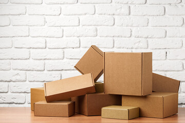Stacked Cardboard Boxes Against A White Brick Wall
