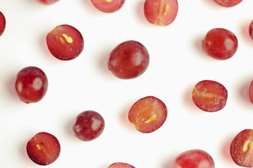 Fresh organic grapes partially sliced ​​and whole with seeds on a white background.