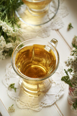 A cup of herbal tea with fresh yarrow flowers