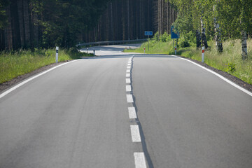 Asphalt road after laying asphalt. New build or road renovation. Black tarmac road after rebuilding, repair, renovation. Construction site is laying new asphalt pavement.