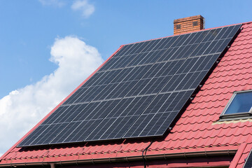 Solar panels on the roof. Red tiles house. Eco-friendly architecture focused on energy saving. Environment protection renewable energy sources.