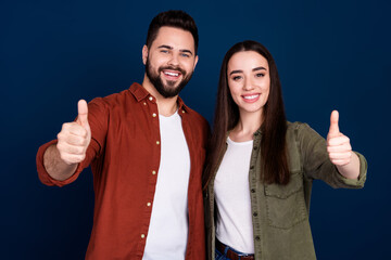 Photo of cheerful nice glad couple wife husband wear trendy clothes thumb up cool offer isolated on dark blue color background