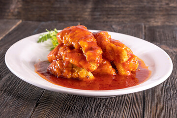 fried fish in sweet and sour sauce on wood table. Chinese food. food concept.