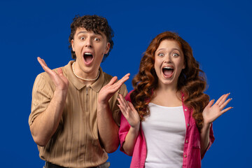 Surprised happy couple expresses WOW, OMG. Impressed man woman. Great, unbelievable news