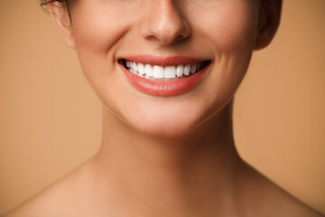 Fototapeta premium Smiling woman on beige background, closeup. Dental veneers