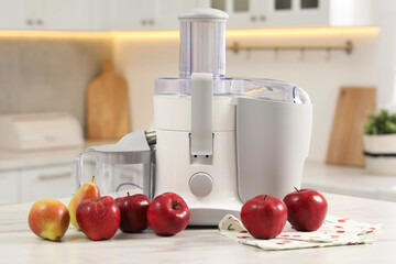 Modern juicer, pears and apples on white marble table in kitchen