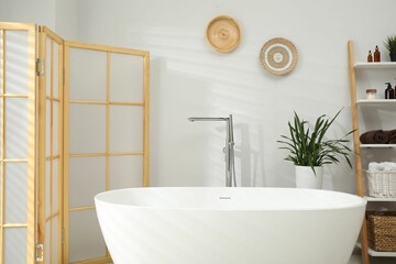Stylish bathroom interior with folding screen and tub