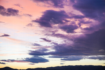 The sky is filled with clouds and the sun is setting