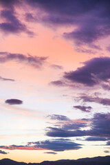 The sky is filled with clouds and the sun is setting