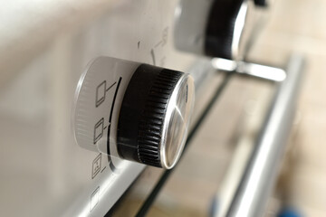 Close-up of the round knobs on a gas stove oven.