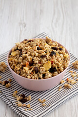 Healthy Homemade Muesli with Fruits in a Pink Bowl, side view.