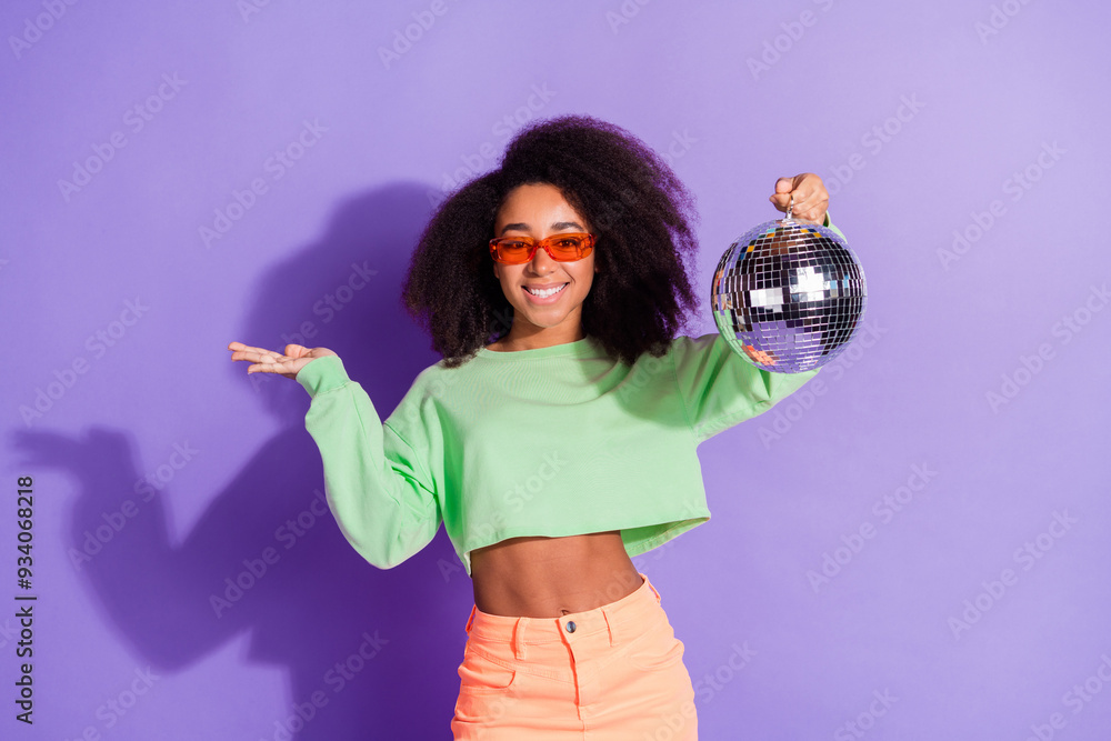 Canvas Prints Photo of young cheerful funny woman wearing green stylish top vintage style discotheque hold discoball isolated on purple color background