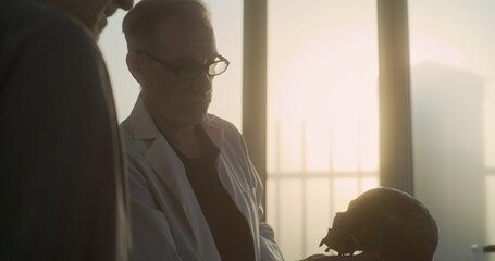 Two archaeologists examine fossil skull, conduct historical and scientific research on remains of...