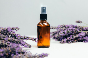 Set of natural cosmetics. Amber bottles with facial, bath liquid on a concrete background with...