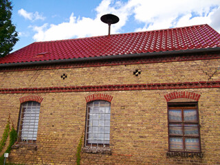 Historisches Klinkergebäude mit Sirene auf dem Dach