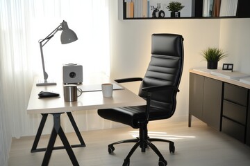 A stylish and minimalist home office with a black chair, wooden desk, lamp, and plant, well-lit by natural light.