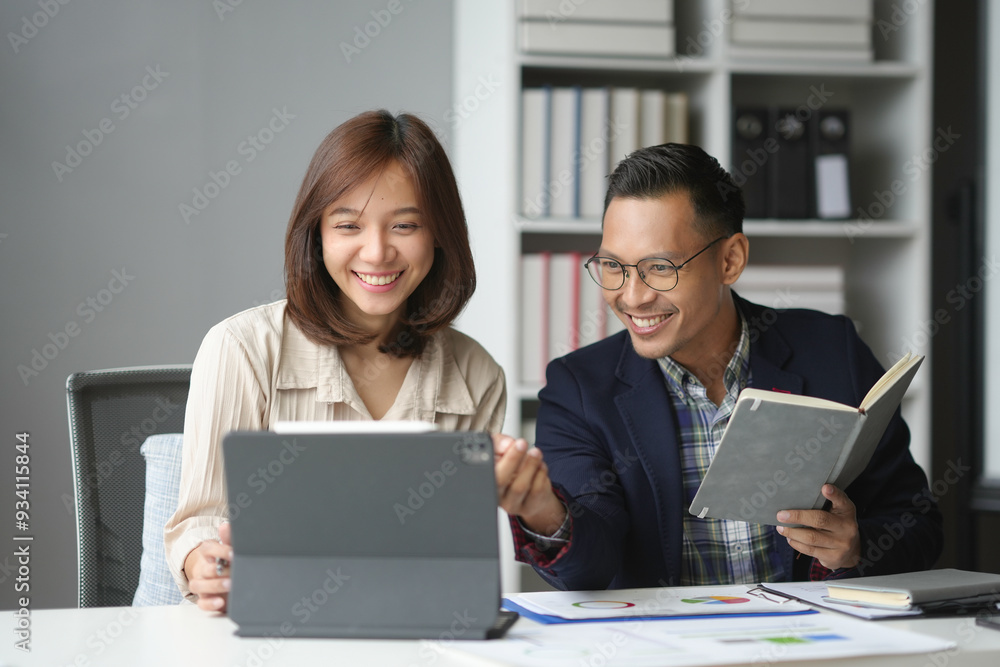 Poster two happy business partners are analyzing data on a digital tablet and discussing a project in a mod