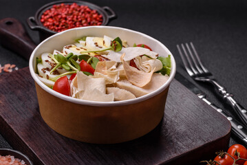 Delicious fresh caesar salad in a bowl with chicken breast, egg, tomatoes