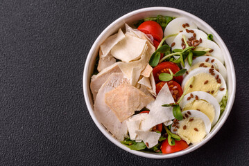 Delicious fresh caesar salad in a bowl with chicken breast, egg, tomatoes