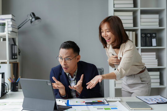 Business partners looking surprised at tablet during a video call in the office, good news and business concept