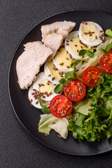 Delicious fresh caesar salad in a bowl with chicken breast, egg, tomatoes