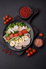 Delicious fresh caesar salad in a bowl with chicken breast, egg, tomatoes