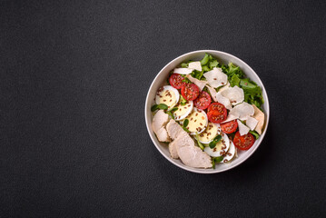 Delicious fresh caesar salad in a bowl with chicken breast, egg, tomatoes