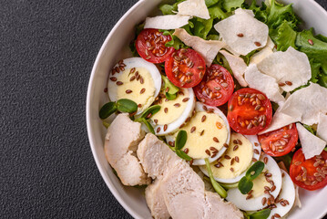 Delicious fresh caesar salad in a bowl with chicken breast, egg, tomatoes