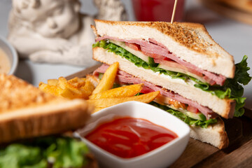 restaurant sandwich with meat and vegetables and with French fries with ketchup