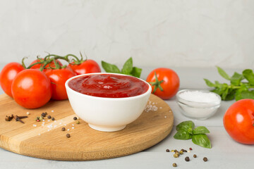 Delicious ketchup with spices and tomatoes on wooden table