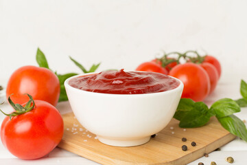 Delicious ketchup with spices and tomatoes on wooden table
