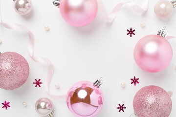 Pink christmas balls with decor on color background, top view